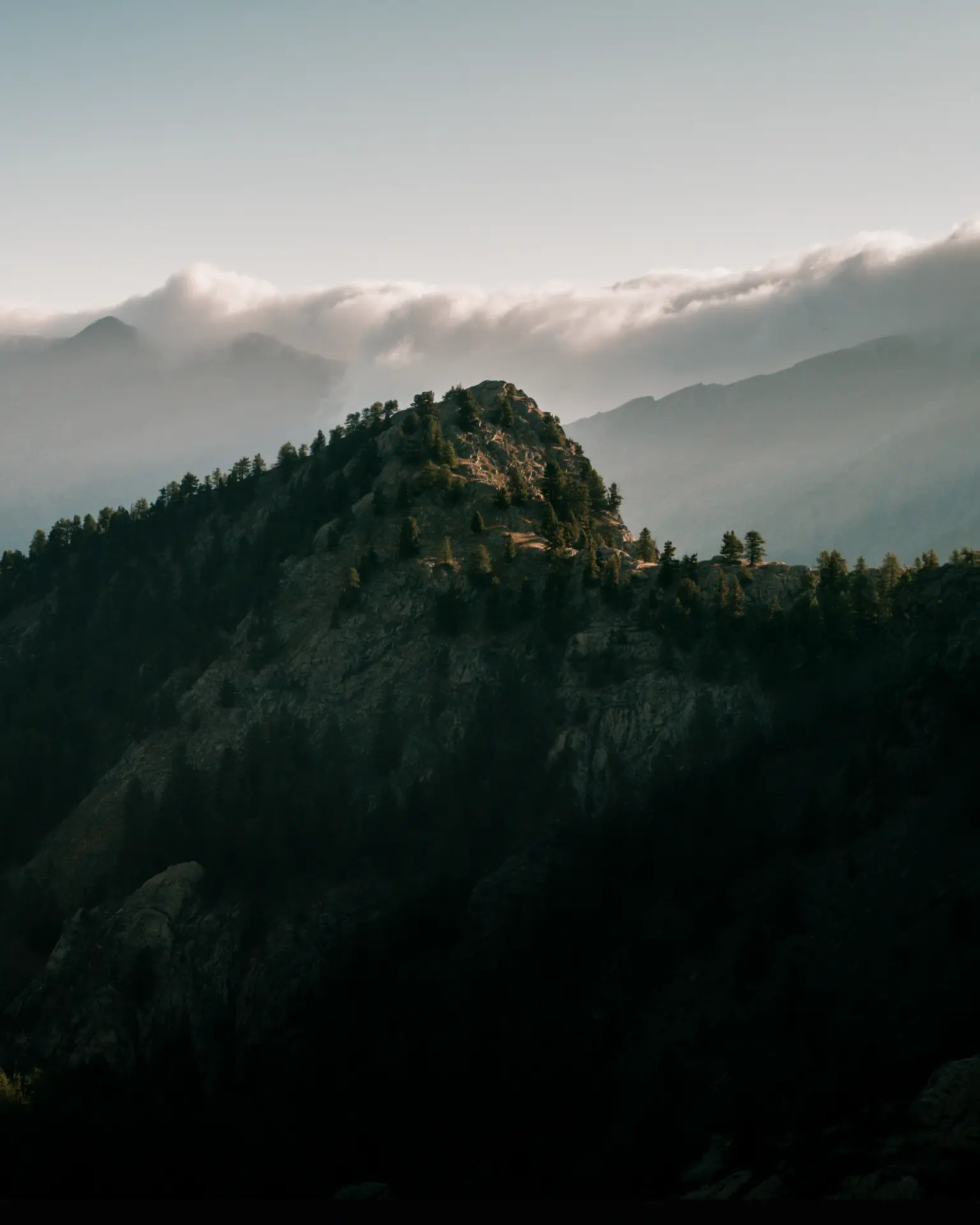 A dark mountain ridge beneath clouds