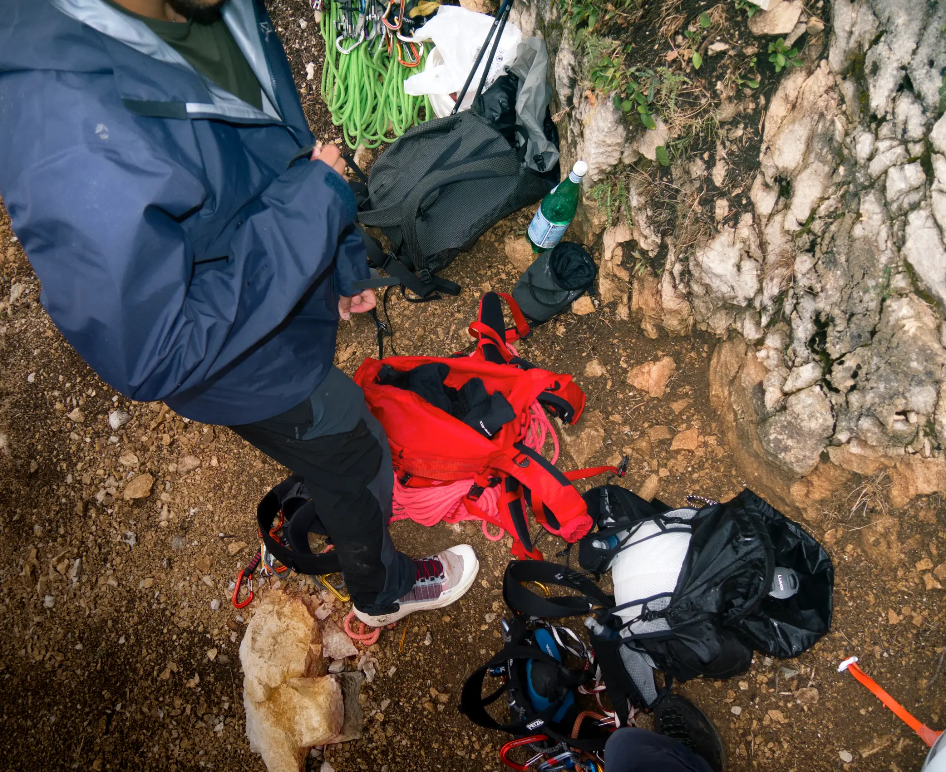 An overhead view of climbing equipment, bags and rope on the ground